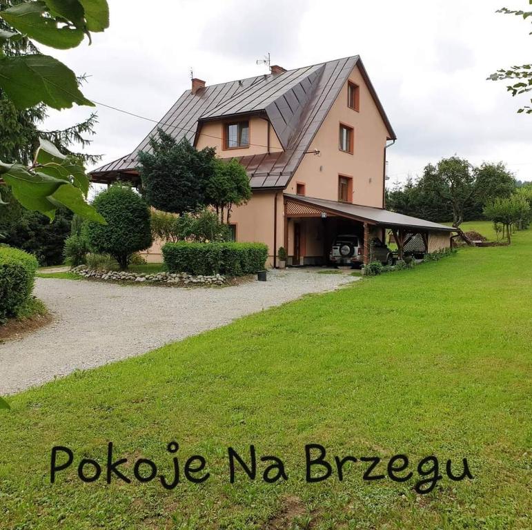 uma casa grande com um relvado verde em frente em Pokoje Na Brzegu 