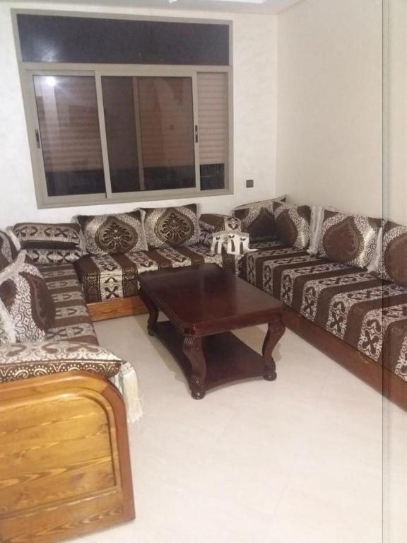 a living room with couches and a coffee table at Appartement Sidi-Bouzid in Sidi Bouzid