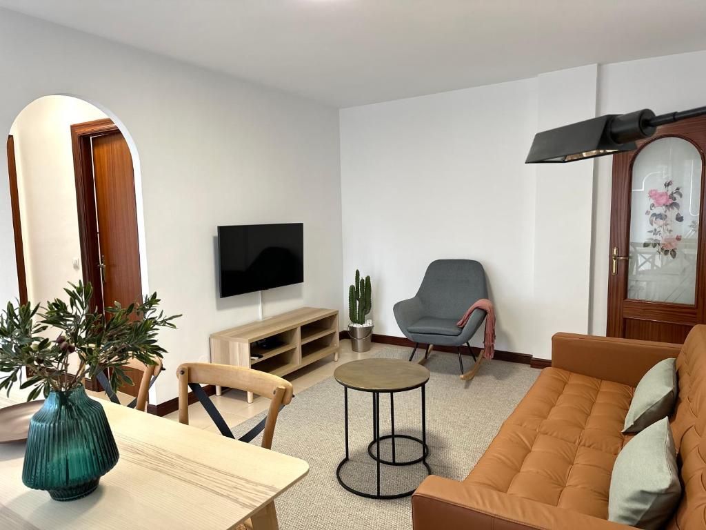 sala de estar con sofá y TV en Apartamento El Olivo, en Noja