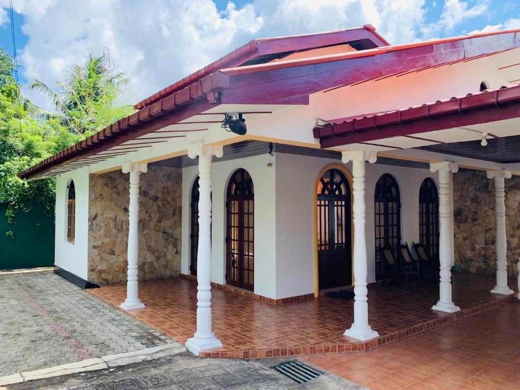 une petite maison blanche avec un toit rouge dans l'établissement Florence Residence Makola, à Kadawata