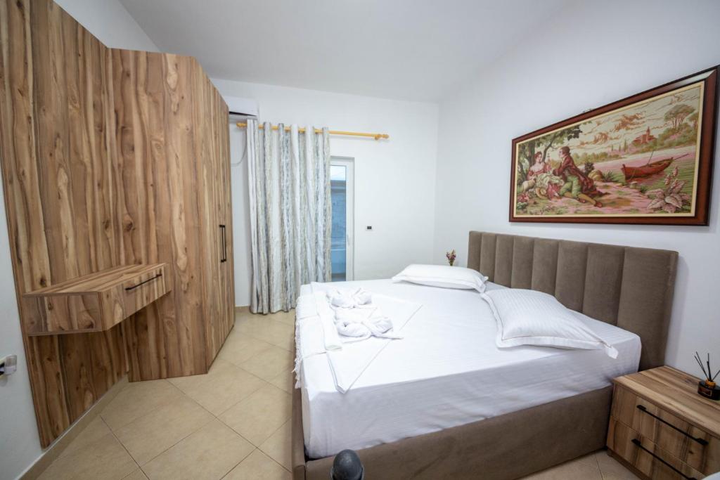 a bedroom with a bed and a painting on the wall at Vila Era Ksamil in Ksamil