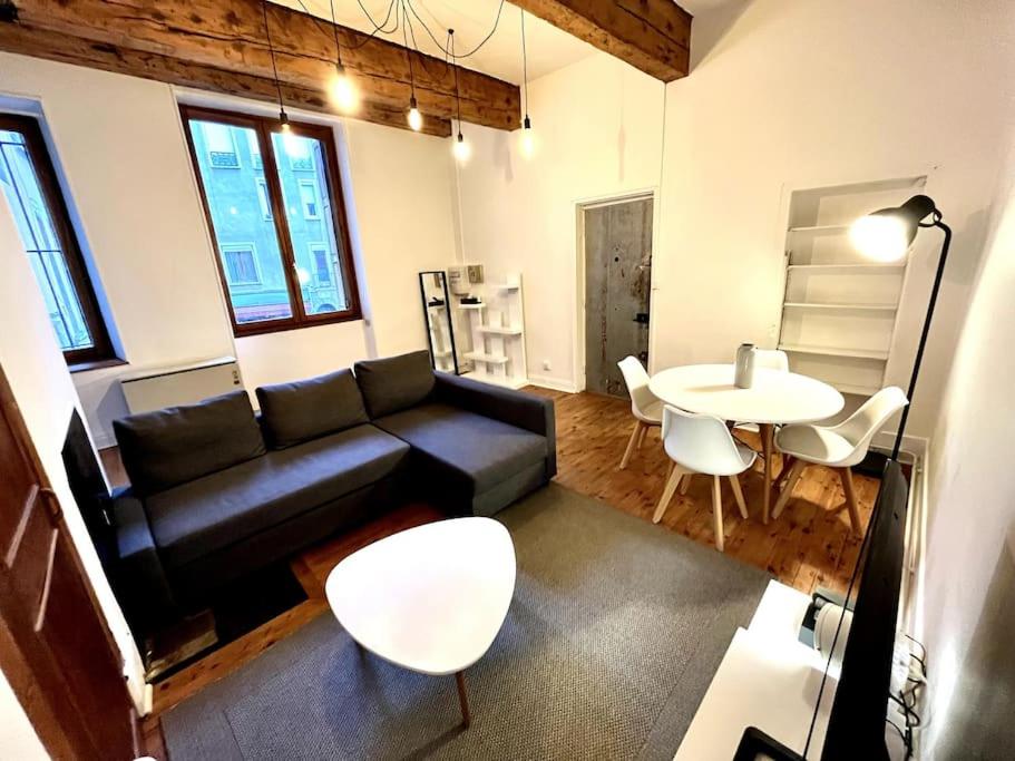een woonkamer met een bank en een tafel bij Grenoble Hypercentre - Appartement vieille ville - Wifi in Grenoble