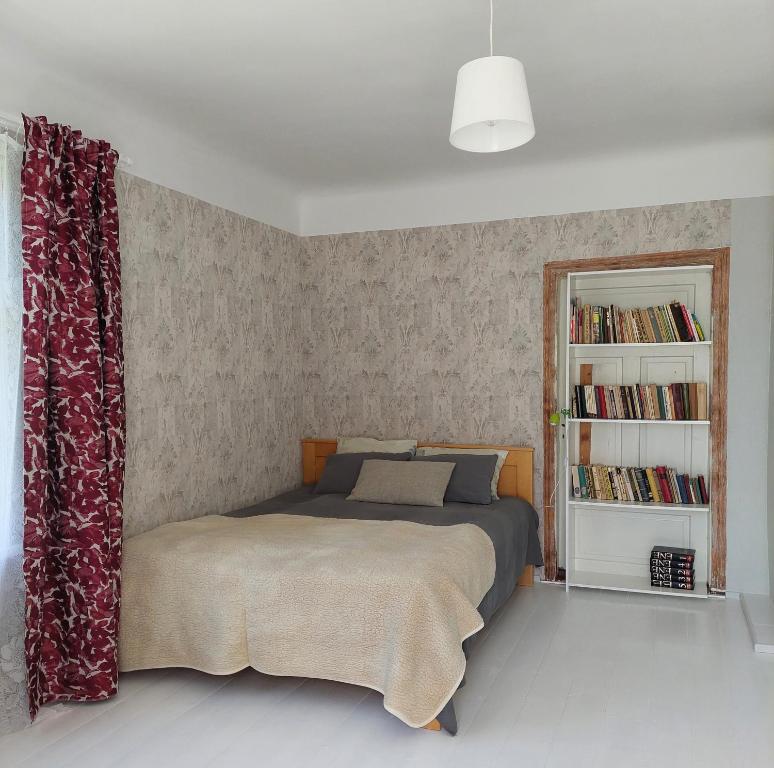 um quarto com uma cama e uma estante de livros em Jõevaara Veskitalu 
