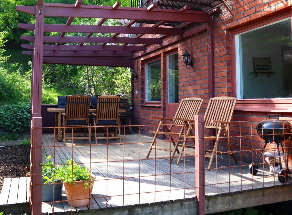 eine Terrasse mit Stühlen, einem Tisch und einem Grill in der Unterkunft Villa with mountain view in the Swedish High Coast in Docksta