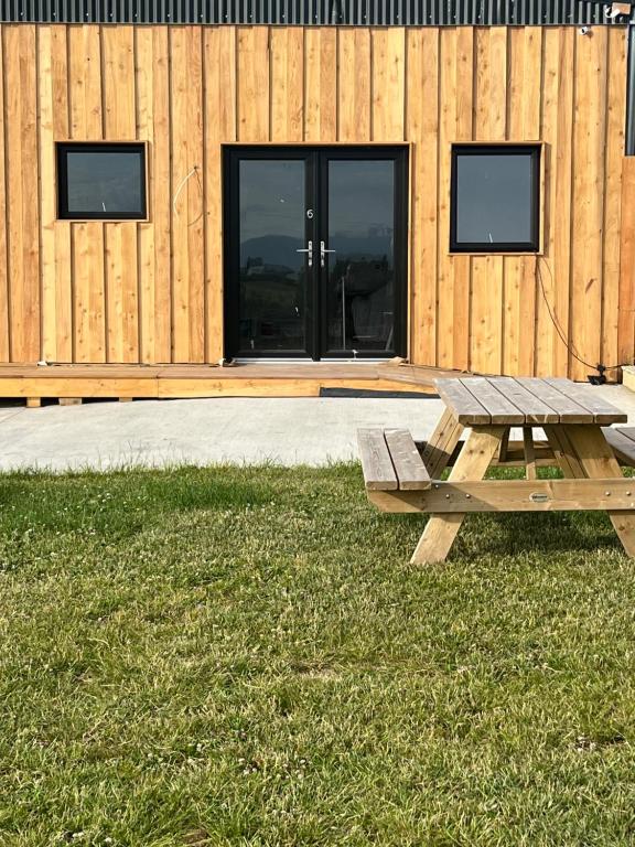a picnic table in the grass in front of a building at Knockreagh Farm Cottages Mountain or Cedar views in Kilkenny