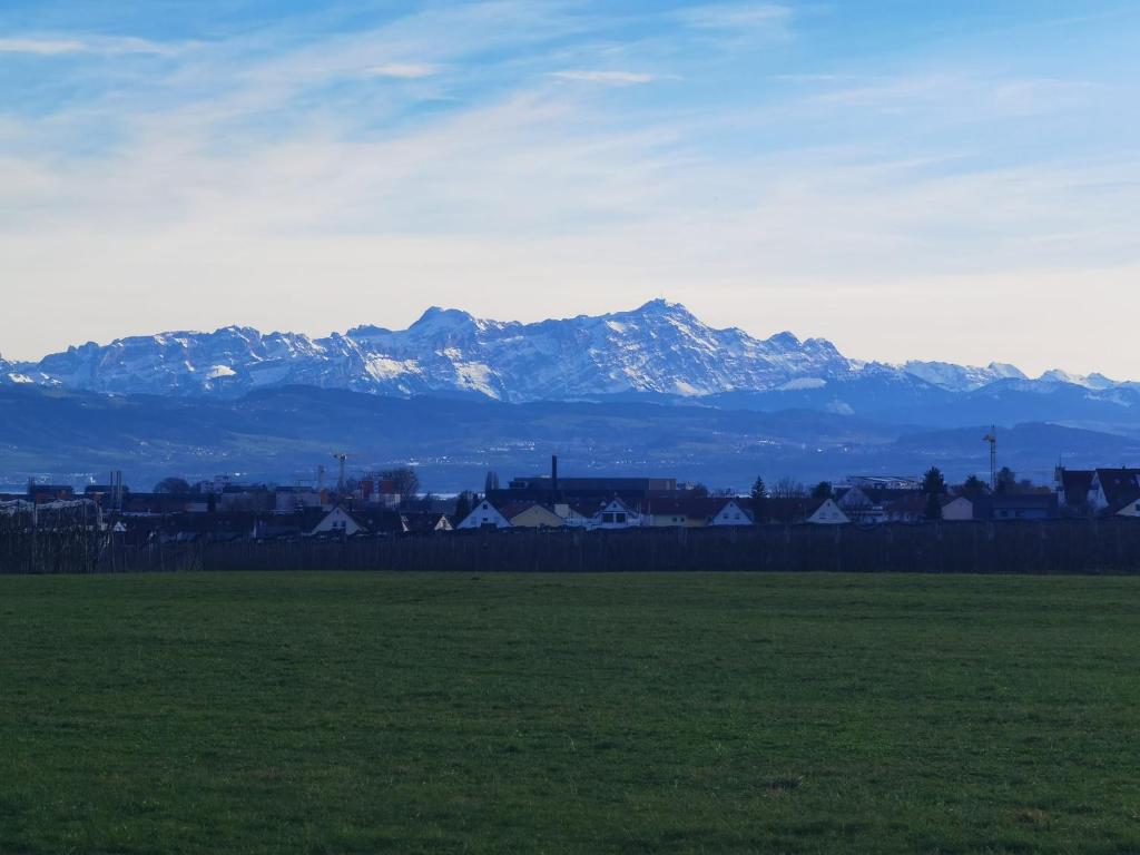a field with a mountain range in the background at Bodensee Life in Friedrichshafen