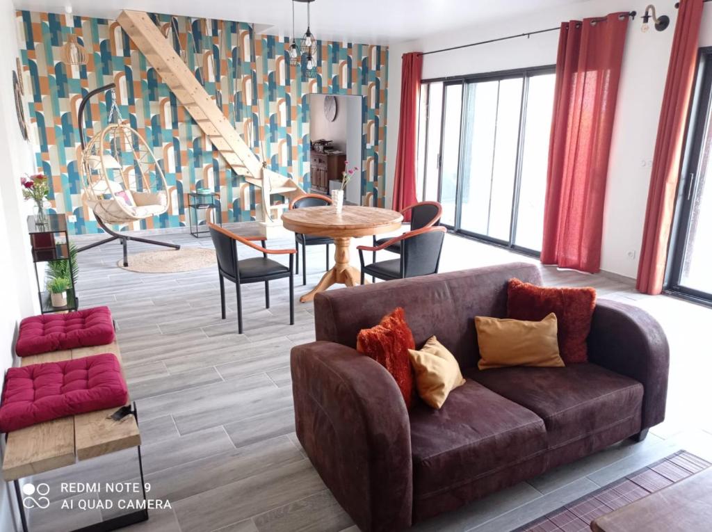 ein Wohnzimmer mit einem Sofa und einem Tisch in der Unterkunft Vacances canal du midi in Ouveillan