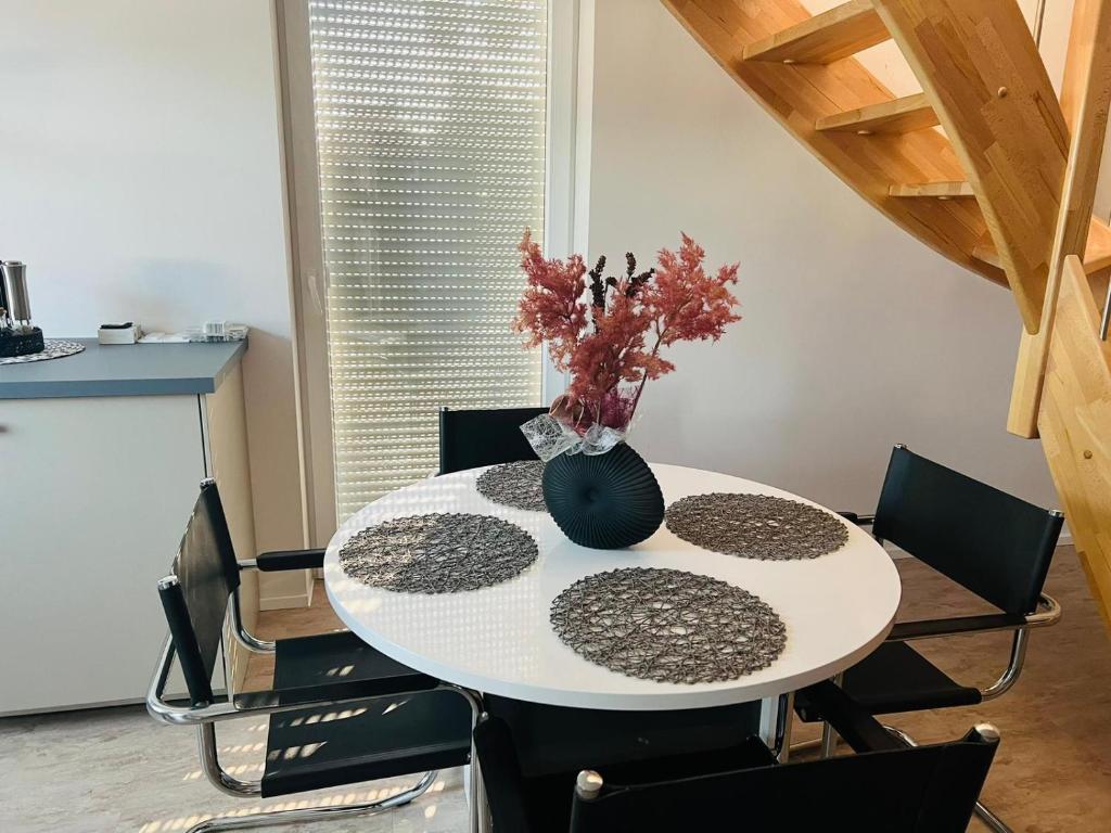 a white dining room table with a vase on it at apartment4me in Burgau
