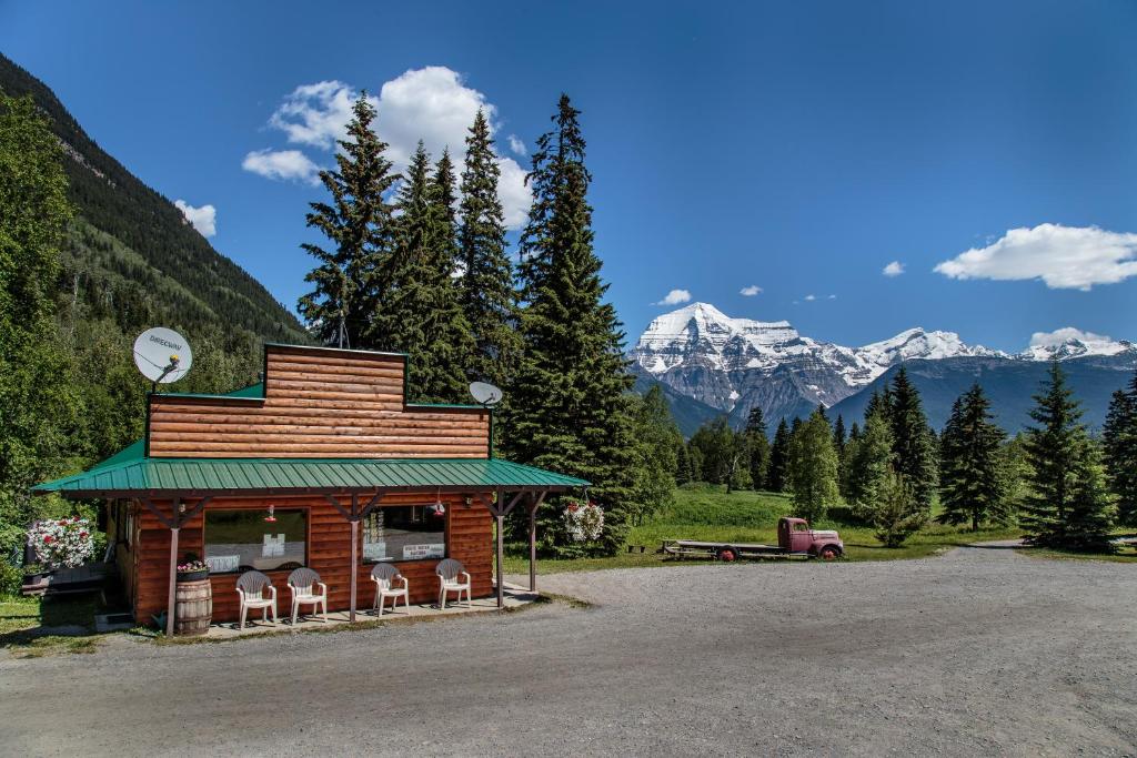 a small building with chairs and mountains in the background at Mount Robson Lodge in Mount Robson