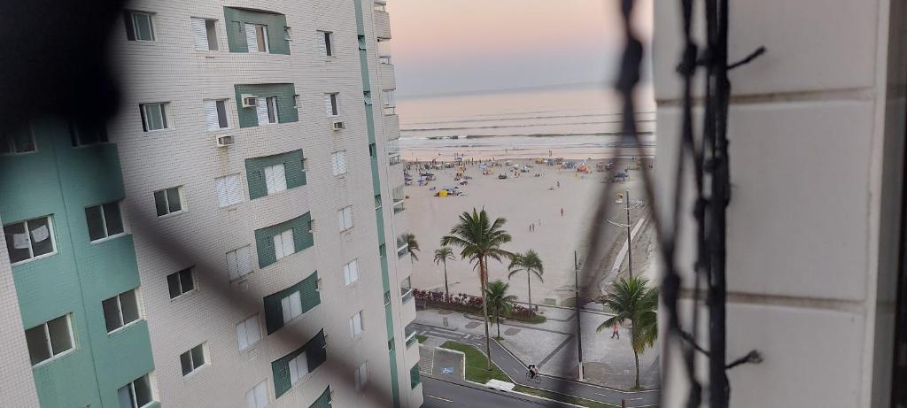 een uitzicht op het strand vanuit een raam van een gebouw bij Apartamento beira mar na Praia Guilhermina,ambiente familiar in Praia Grande