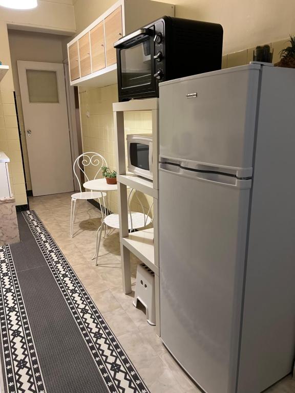 uma cozinha com um frigorífico e um micro-ondas em Nosso Aconchego em Sacavém
