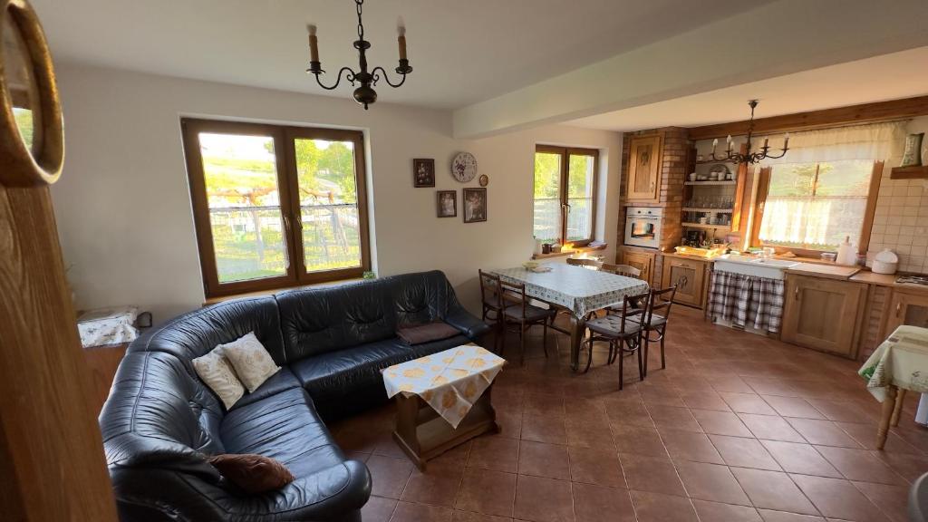 a living room with a leather couch and a table at Dom w sercu Kaszub in Parchowo