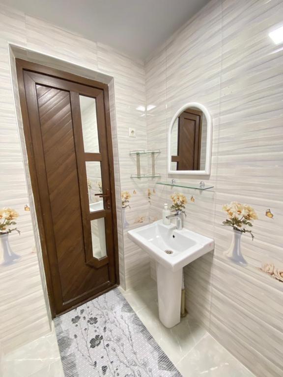 een witte badkamer met een wastafel en een spiegel bij Апарт Отель in Poti