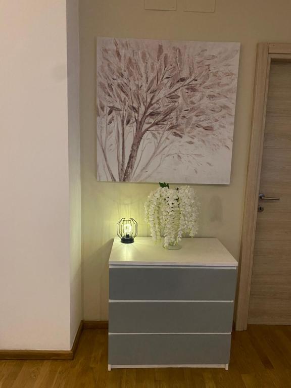un tocador con flores y una pintura en la pared en Luxury center appartment en Novi Ligure