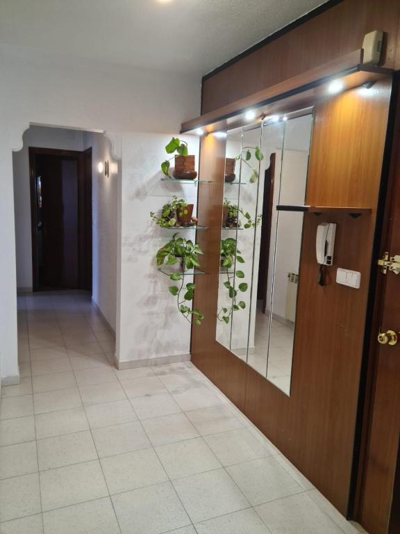a hallway with a door with plants on the wall at Allotjament dels Ports in La Senia