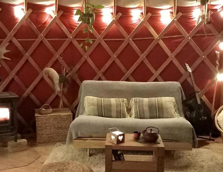 1 dormitorio con 1 cama con pared roja en Yourte Immersion Nature en Saint-Étienne-de-Chomeil