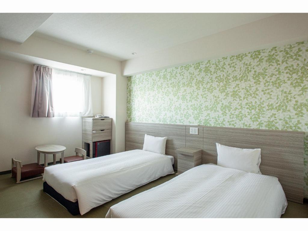 Postel nebo postele na pokoji v ubytování Kuretake Inn Premium Tajimi Ekimae