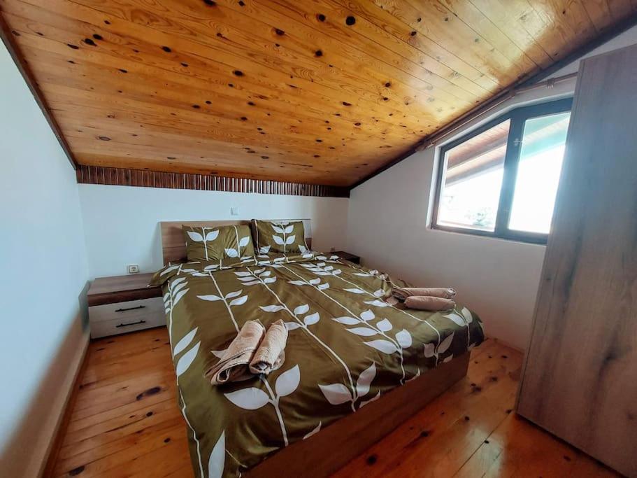 1 dormitorio con cama y techo de madera en Villa Stone Tree - Ljubanista, en Ohrid