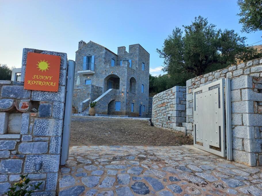 a building with a gate in front of a stone wall at Sunny Kotronas in Kotronas