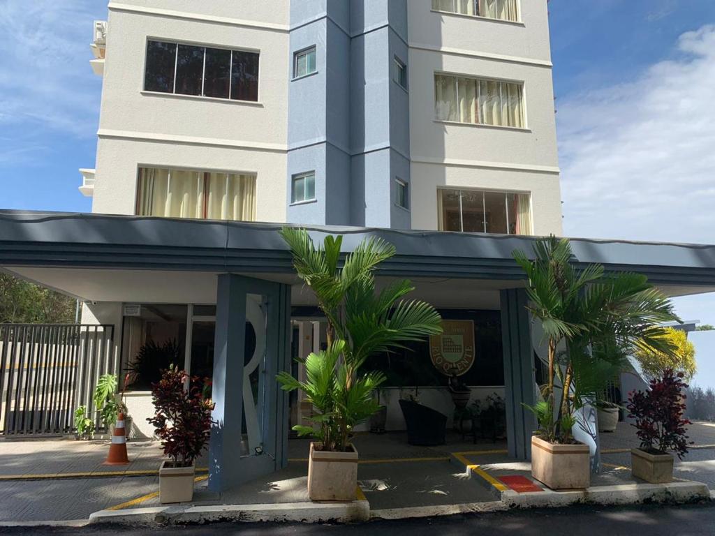 a building with palm trees in front of it at Flat DiRoma - Rio Quente in Rio Quente