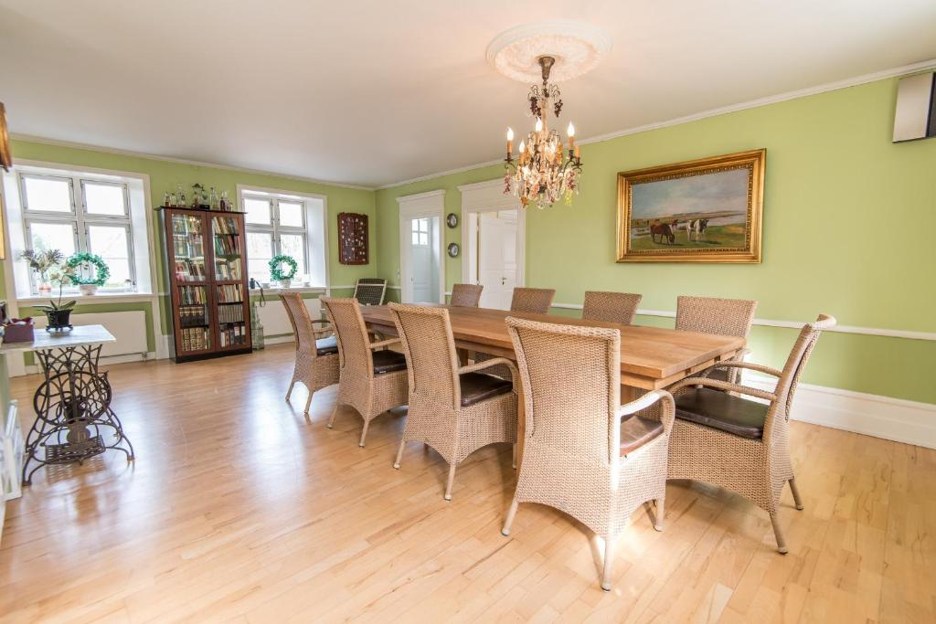 a dining room with a wooden table and chairs at 300m2 entire house with 3 bedrooms in Tistrup