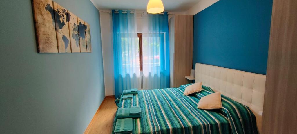 1 dormitorio con 1 cama con pared azul en Chez Marie-Claire, en Montjovet