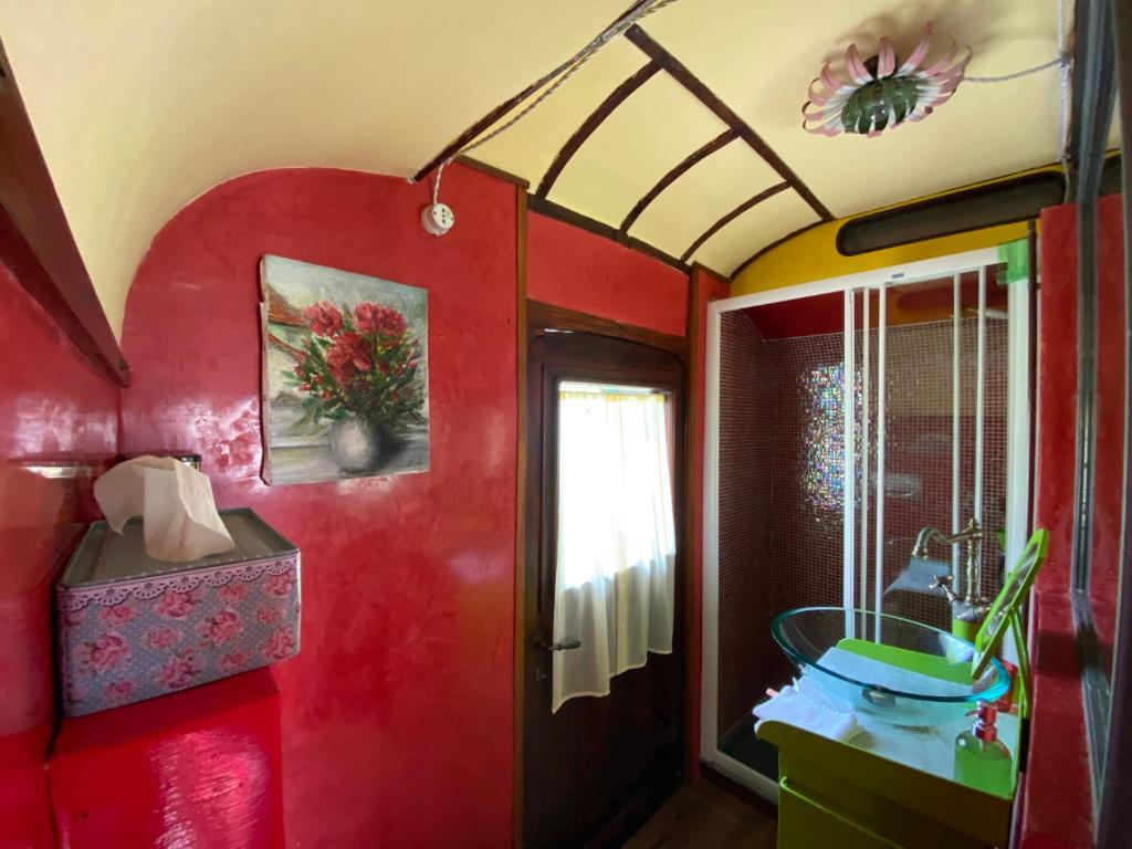 a room with a red wall with a window and a tub at Azienda agricola Della Mezzaluna in Stiava