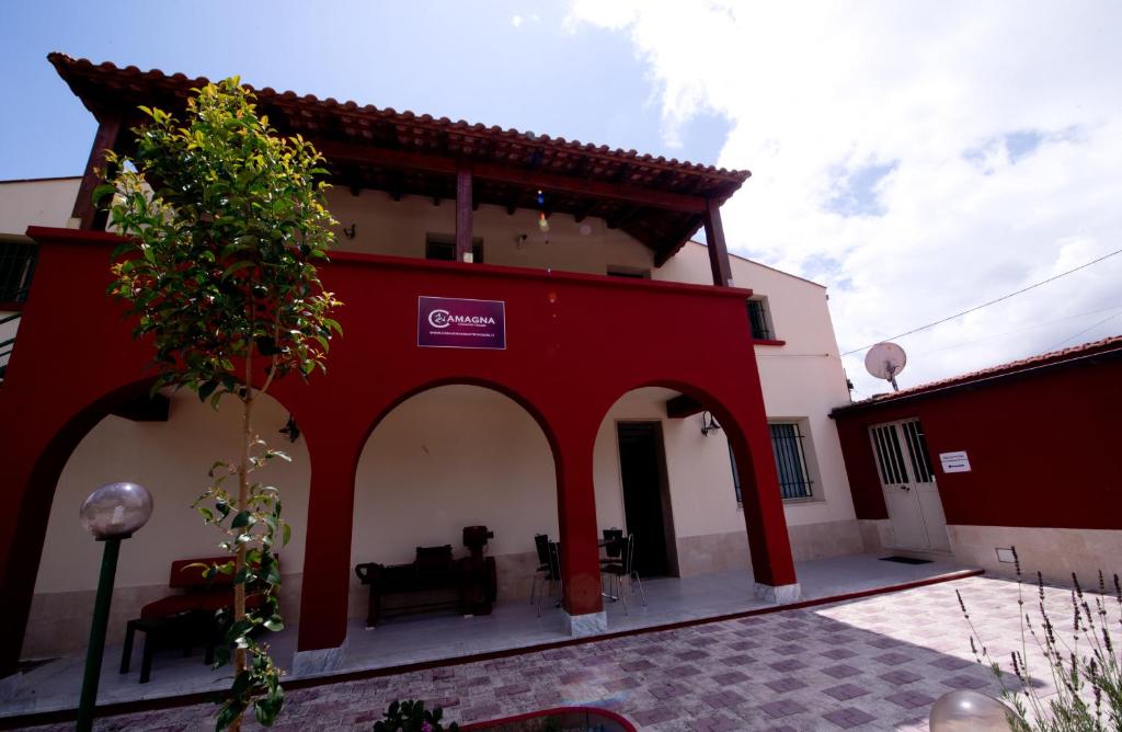 un edificio rojo y blanco con porche en Camagna Country House en Santa Ninfa