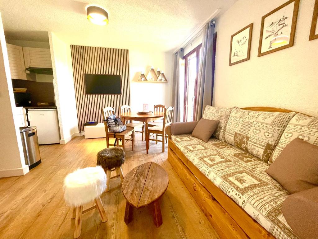 uma sala de estar com um sofá e uma mesa em Appartement 6 couchages, Tout confort, pieds des pistes em Montclar