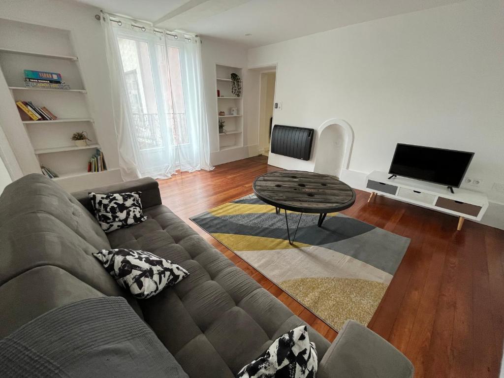 - un salon avec un canapé et une table dans l'établissement Bel appartement Voiron centre, à Voiron