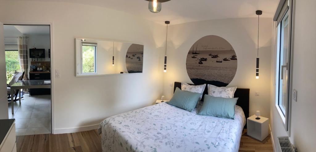 a bedroom with a large bed and a mirror at Ker Neizh Cancale, Cottage Baie de Cancale GR34 in Cancale