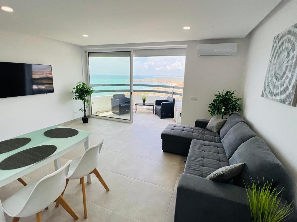 sala de estar con sofá y mesa en Top Ocean View Apartment - amazing sunset - modern style - pool & 200m to beach, en Portimão