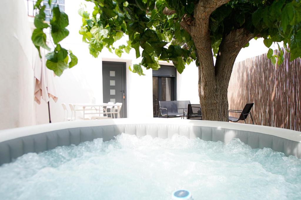 a hot tub in a backyard with a tree at Villa Carmensin in Deltebre