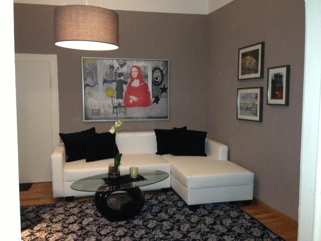 a living room with a white couch and a table at Ferienwohnung am Gärtnermuseum in Bamberg