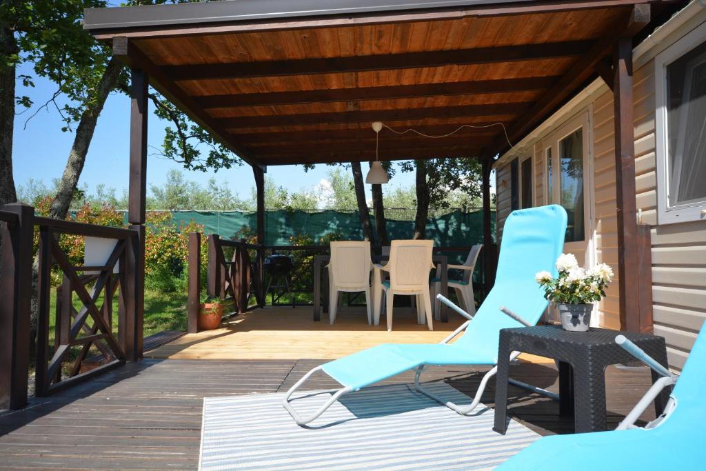 a patio with chairs and a table on a deck at West Coast Mobilhome with XXL Terrace in Naturist Resort Solaris FKK in Poreč