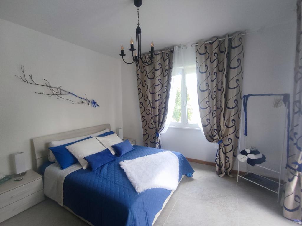 a bedroom with a blue and white bed and a window at Tirano Express Apartments in Tirano