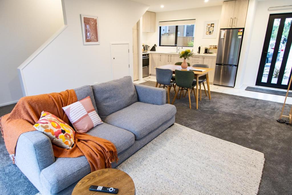 sala de estar con sofá azul y cocina en Tranquil 2 bed townhouse w/carparking, en Christchurch