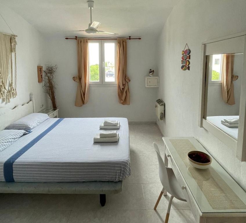 1 dormitorio con cama, mesa y espejo en Atico excelente en Menorca Ciutadella Calan Blanes, en Cala en Forcat