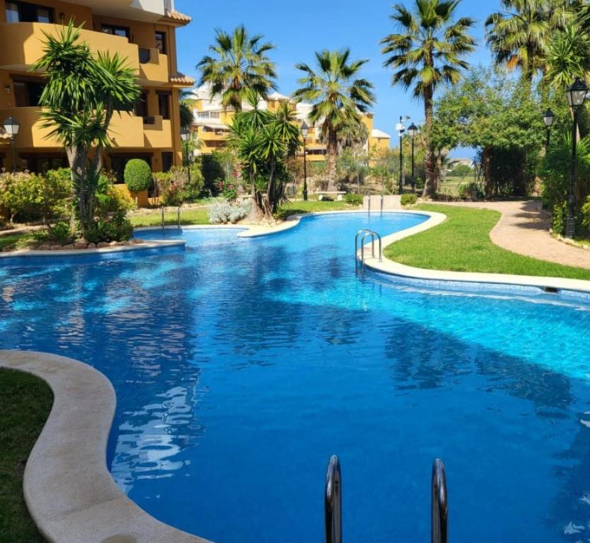 una piscina en un complejo con palmeras en Apartamento Sultan, Punta Prima, Panorama Park, 2 bed & 2 beautiful swimming pools, en Punta Prima