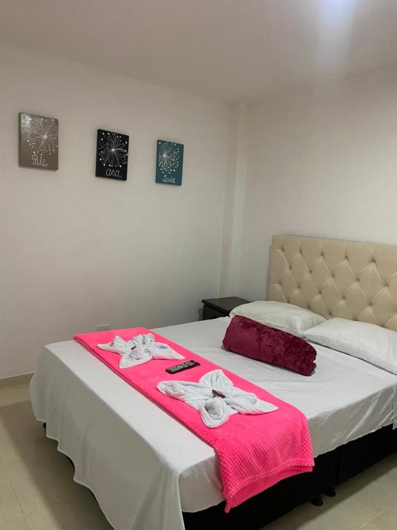 a bedroom with two beds with pink towels on them at Mi Balconcito in Salento