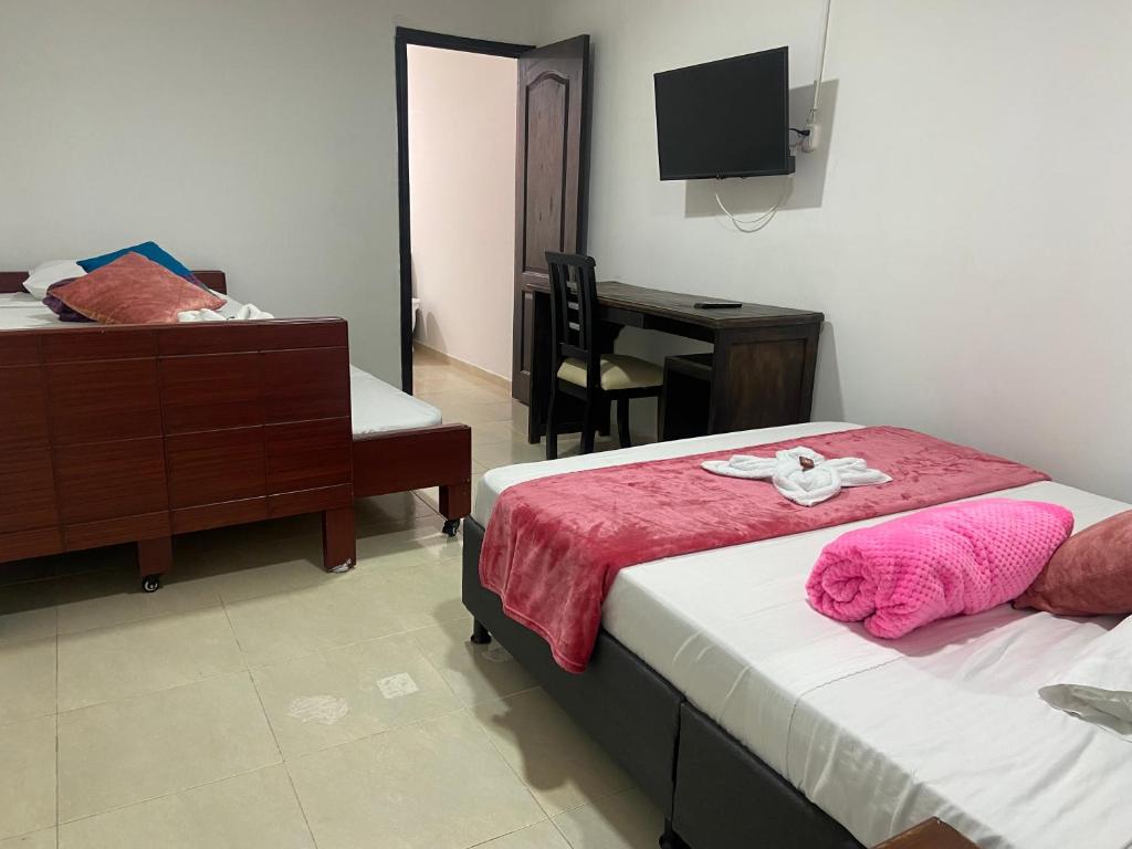 a hotel room with two beds and a desk at Mi Balconcito in Salento