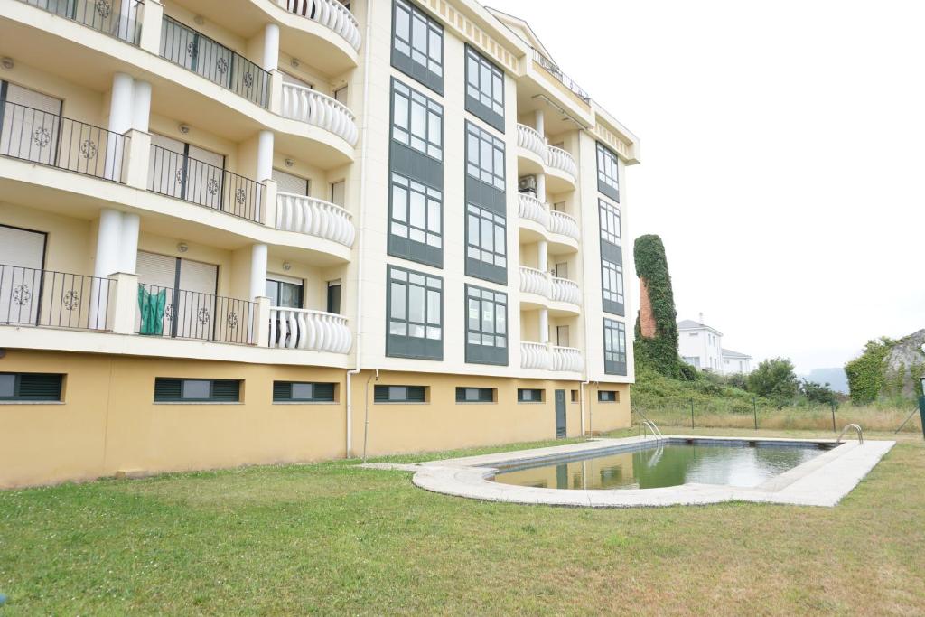 un edificio de apartamentos con piscina en el patio en Hermanas Iglesias, en O Vicedo