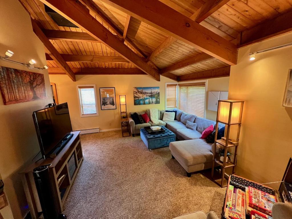 a living room with a couch and a tv at Exposed Beam 3BR Modern Mountain Retreat in Thornton