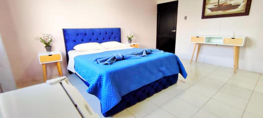 a blue bed with a blue blanket in a room at Bahía Gardner in Puerto Baquerizo Moreno