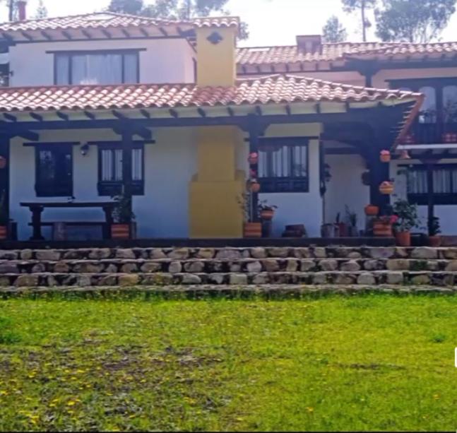 una casa con una puerta amarilla y un patio en Finca villa Claudia a 25 min de villa de Leyva, en Villa de Leyva