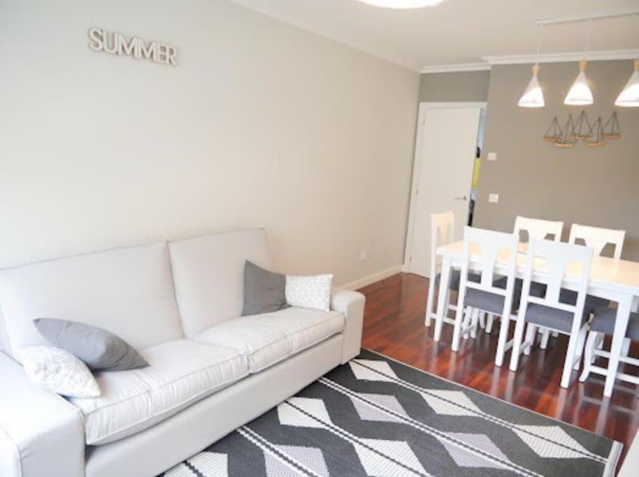 een woonkamer met een witte bank en een eetkamer bij Concheira Deluxe, precioso apartamento in Baiona