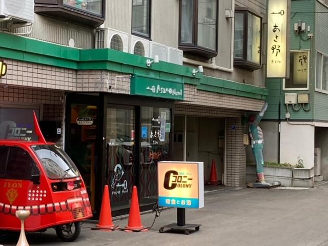 un coche aparcado fuera de una tienda con un cartel delante en Asano Hotel, en Sapporo