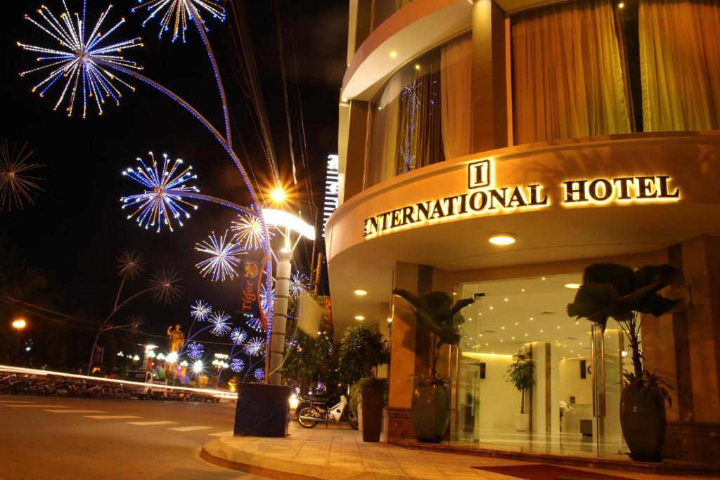 a building with fireworks in the sky next to a street at International Hotel in Can Tho