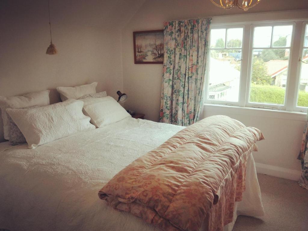 a bedroom with a large white bed with a window at Seaview Sefton in Timaru
