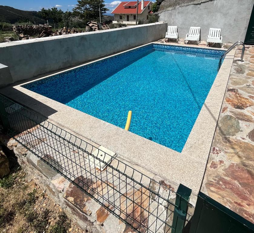 a swimming pool with two chairs and a swimming pool at Casa do Canto in Macedo de Cavaleiros